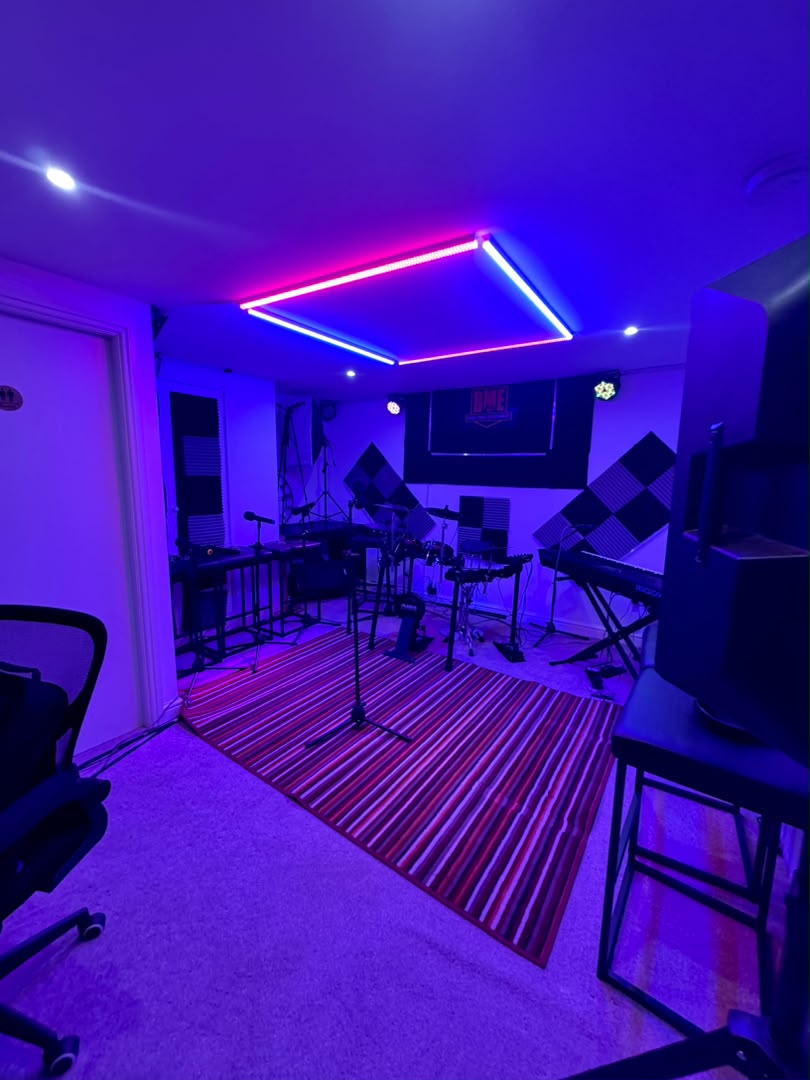 Wide view of the neon-lit Bhablo studio with instruments and acoustic panels